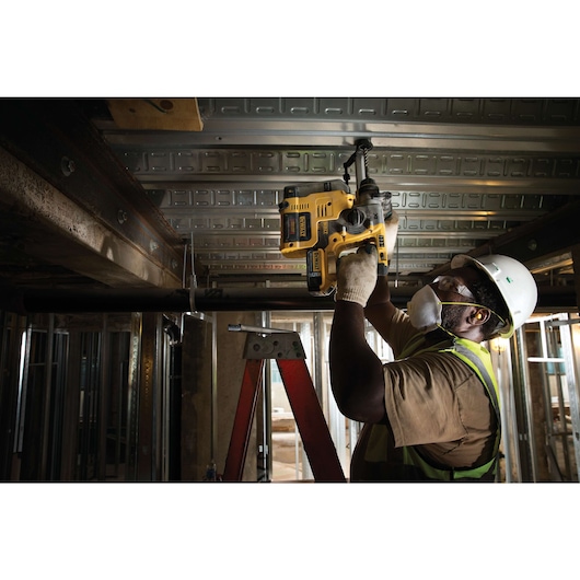 Dust extractor for MAX SDS hammer being used by person