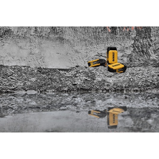 x3 Powershift 554WH batteries sit on concrete rubble and are reflected in water in the foreground