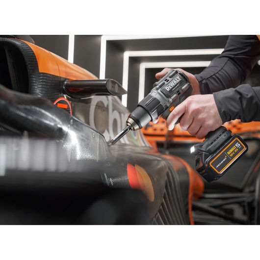 McLaren mechanic using DEWALT/McLaren drill driver on McLaren racing car
