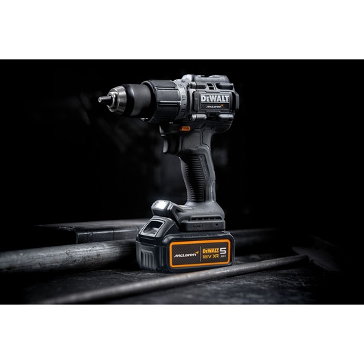 DEWALT/McLaren Drill Driver with 18V XR 5Ah battery 3/4 view in staged dark setting
