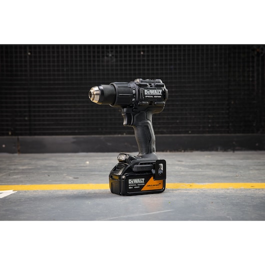 DEWALT x McLaren F1 Team 18V XR Special Edition Hammer Drill Driver with 4Ah battery standing on a concrete floor