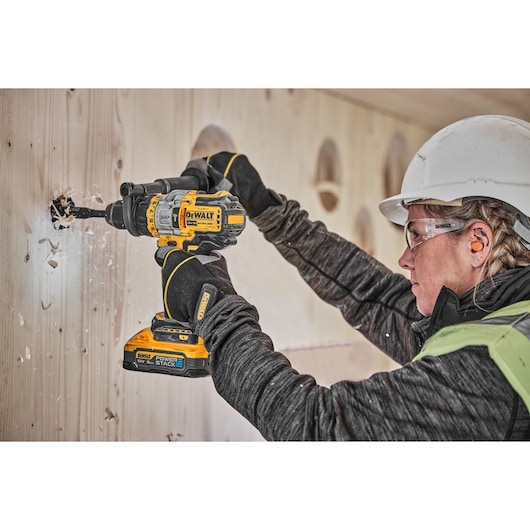 18V XR Brushless drill driver with Powerstack battery cutting hole into wooden wall