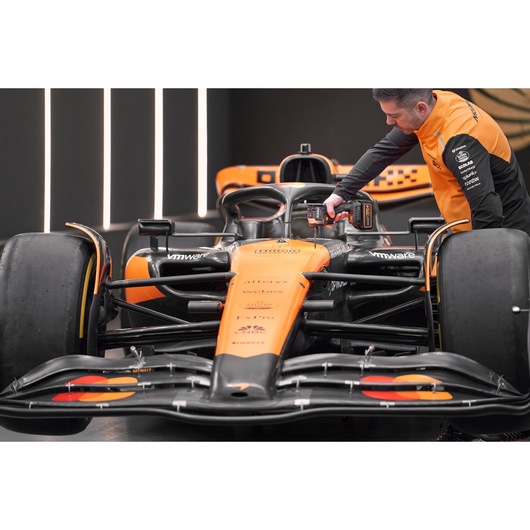 McLaren mechanic using DEWALT/McLaren impact driver on McLaren racing car