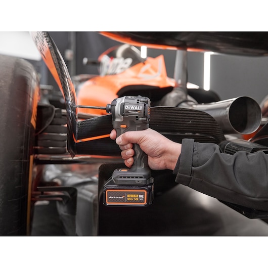 Close view of DEWALT/McLaren impact driver being used on McLaren racing car