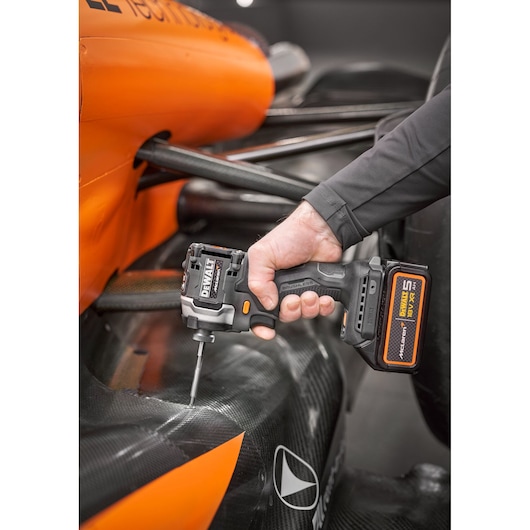 Close view of DEWALT/McLaren impact driver being used on McLaren racing car