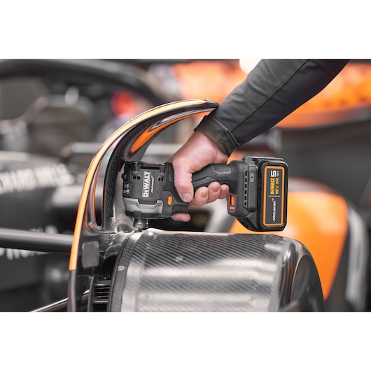 Close view of DEWALT/McLaren impact driver being used on McLaren racing car