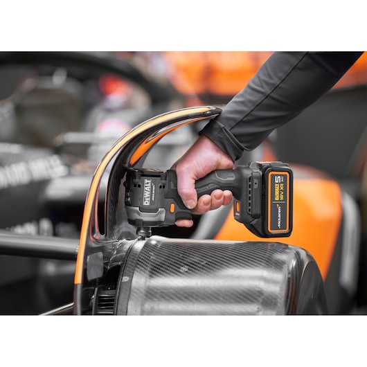 Close view of DEWALT/McLaren impact driver being used on McLaren racing car