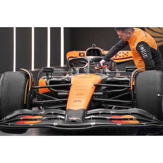 McLaren mechanic using DEWALT/McLaren impact driver on McLaren racing car