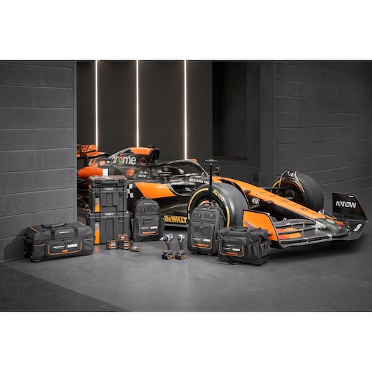 Limited Edition DEWALT/McLaren storage bags, Tstak trolley, impacts and accessory boxes displayed in front of a McLaren racing car