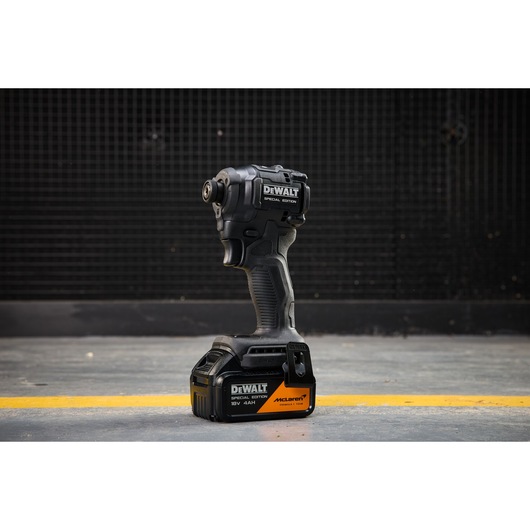 DEWALT x McLaren F1 Team 18V XR Special Edition Impact Driver with 4Ah battery standing on a concrete floor