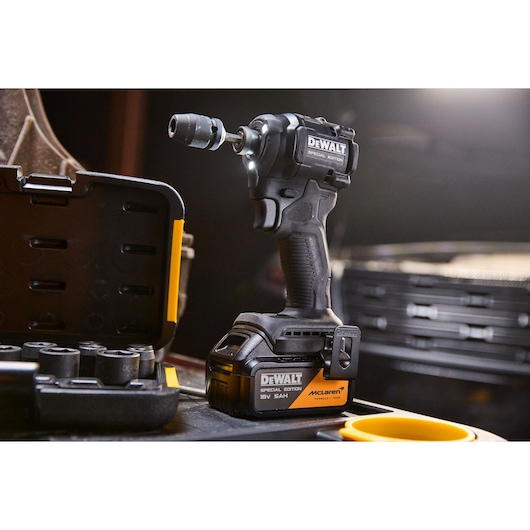 DEWALT x McLaren F1 Team 18V XR Special Edition Impact Driver with 5Ah battery standing next to a socket set