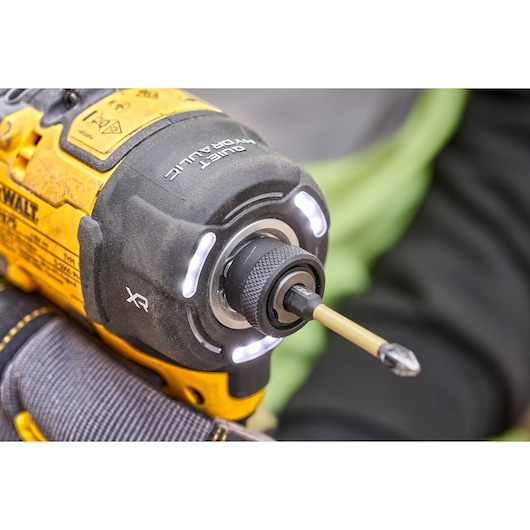 Close view of DCF870 18V XR Brushless impact driver chuck with screwdriving bit. Tool work lights are illuminated