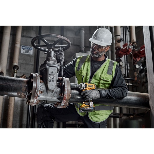 18V XR Brushless Impact Wrench tightening a bolt in an industrial setting