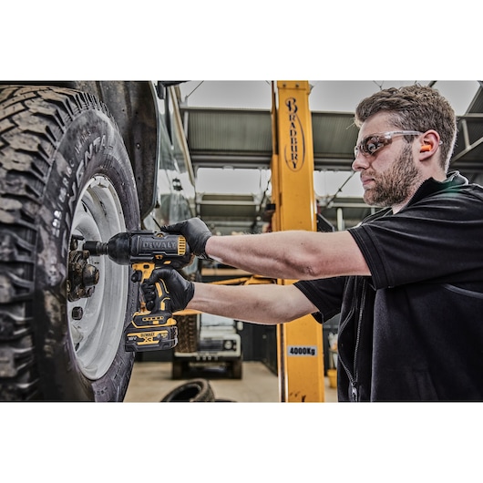 MECHANIC USING A DEWALT 18V XR IMPACT WRENCH TO TIGHTEN LARGE DIAMTER WHEEL NUTS