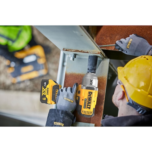 A TRADESMAN USING AN 18V XR IMPACT WRENCH FOR STEEL FRAME CONSTRUCTION