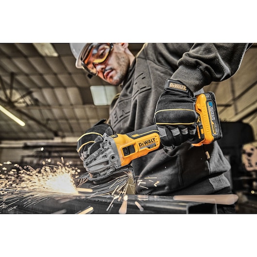 18V XR Brushless 125mm Grinder right side close up grip grinding metal in factory