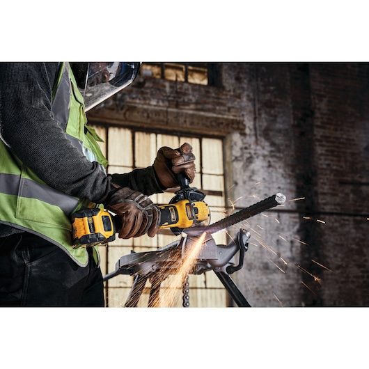 A tradesman using a DCG409VST1 to cut rebar