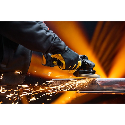 DEWALT x McLaren F1 Team 18V XR Special Edition Grinder with 5Ah battery grinding a metal bar