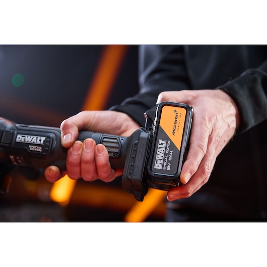 5Ah battery being attached to the DEWALT x McLaren F1 Team 18V XR Special Edition Grinder