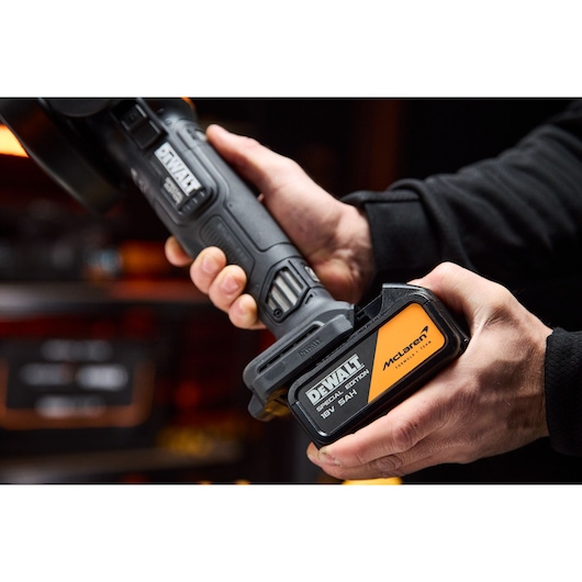 5Ah battery being attached to the DEWALT x McLaren F1 Team 18V XR Special Edition Grinder