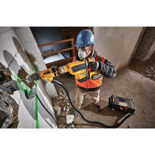 Brushless, cordless SDS MAX combination rotary hammer being used by a person