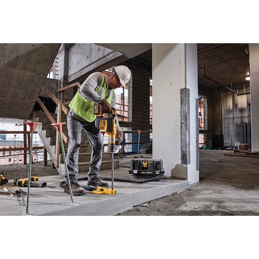 Brushless, cordless SDS MAX combination rotary hammer being used by a person