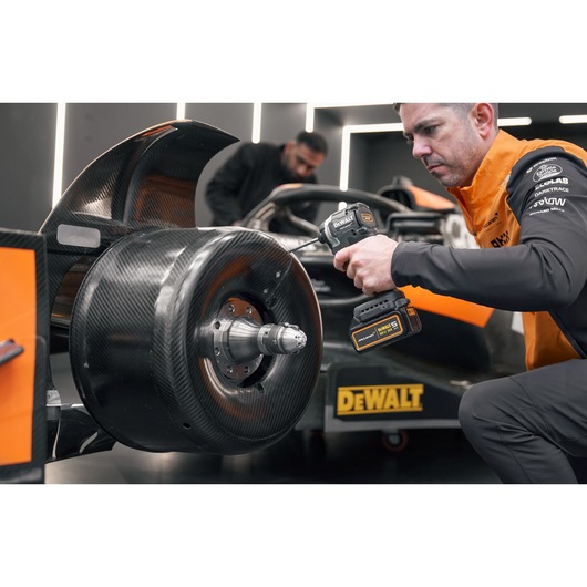 McLaren mechanic using DEWALT/McLaren drill driver on McLaren racing car