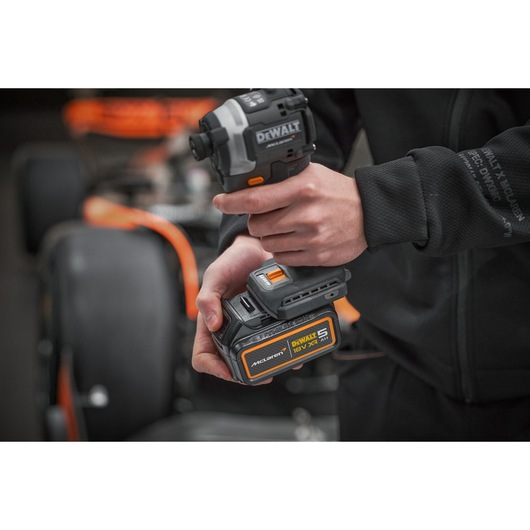 Battery being connected to a DEWALT/McLaren drill driver