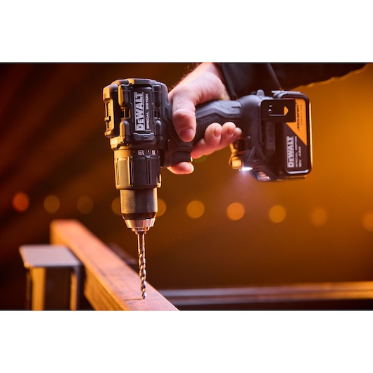 DEWALT x McLaren F1 Team 18V XR Special Edition Hammer Drill Driver with 4Ah battery drilling a metal bar