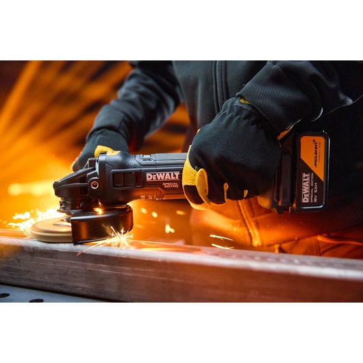 DEWALT x McLaren F1 Team 18V XR Special Edition Grinder with 5Ah battery grinding a metal bar