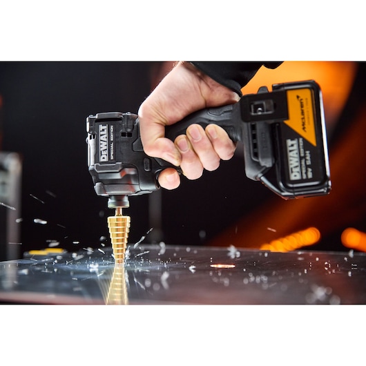 DEWALT x McLaren F1 Team 18V XR Special Edition Compact Impact Driver with 5Ah battery drilling a metal sheet