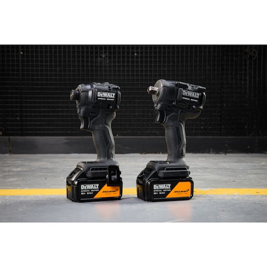 DEWALT x McLaren F1 Team 18V XR Special Edition Compact Impact Driver and Impact Wrench with 5Ah batteries standing on a concrete floor