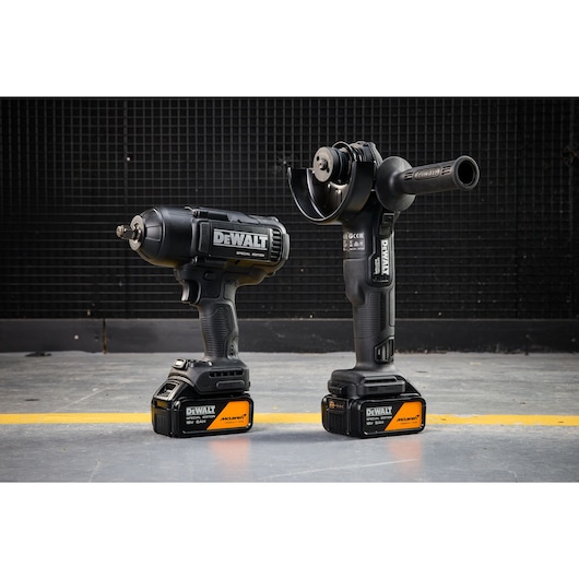 DEWALT x McLaren F1 Team 18V XR Special Edition Impact Wrench and Grinder with 5Ah batteries standing on a concrete floor