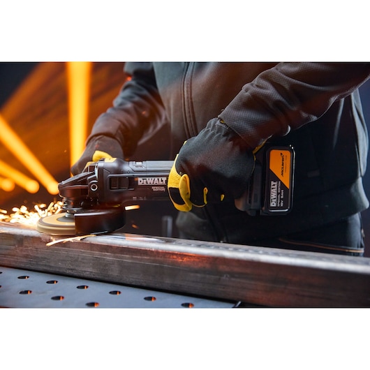 DEWALT x McLaren F1 Team 18V XR Special Edition Grinder with 5Ah battery grinding a metal bar