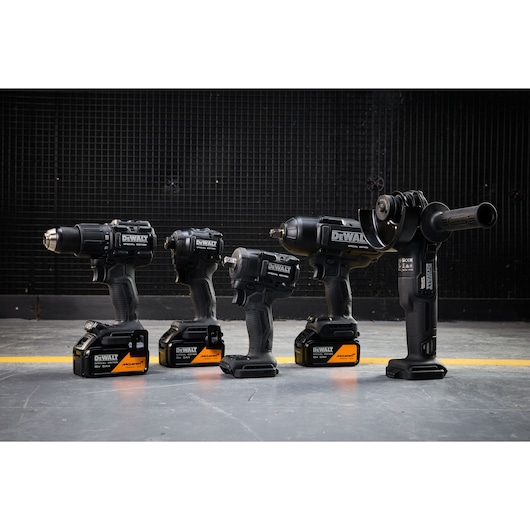 DEWALT x McLaren F1 Team 18V XR Special Edition Hammer Drill Driver, Compact Impact Driver, Impact Driver, Impact Wrench and Grinder with 5Ah batteries standing on a concrete floor