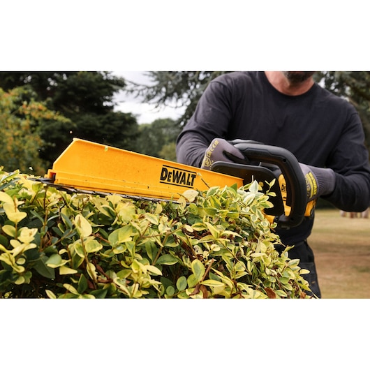 Close view of the DEWALT 18V XR Brushless Hedge Trimmer with hedge sweep attachment
