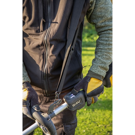 54V garden tool used by gloved person in outdoor work for efficient landscaping tasks.