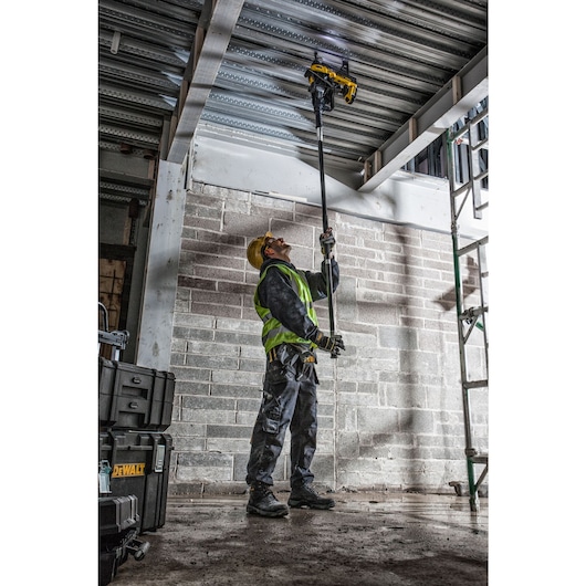 Cordless Concrete Nailer being used by a person to fix nuts on metallic board.