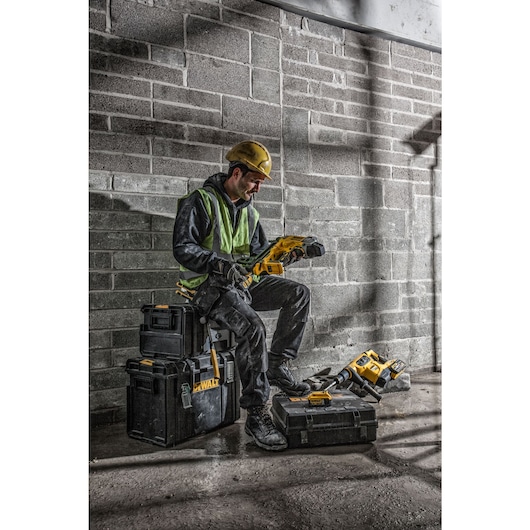 Cordless Concrete Nailer being used by a person to fasten nails into wooden plank.