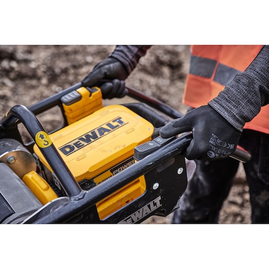 Construction worker presses speed settings on Powershift Rammer