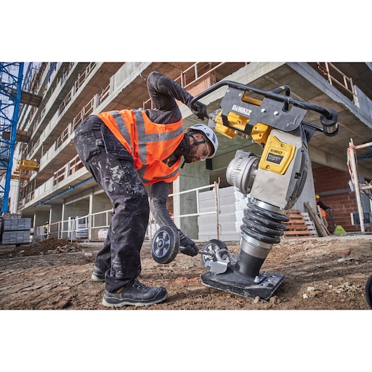 Construction worker fixing transportation wheels to Powershift Rammer