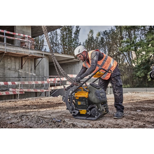 Worker attaches crane hook and chains to Powershift Plate Compactor