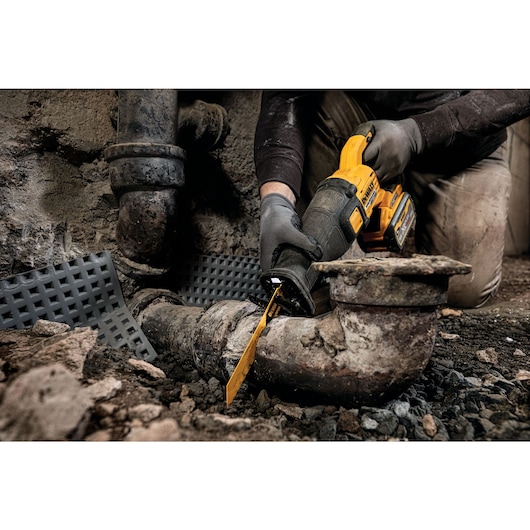 FLEXVOLT brushless cordless reciprocating saw being used by person on wood.
