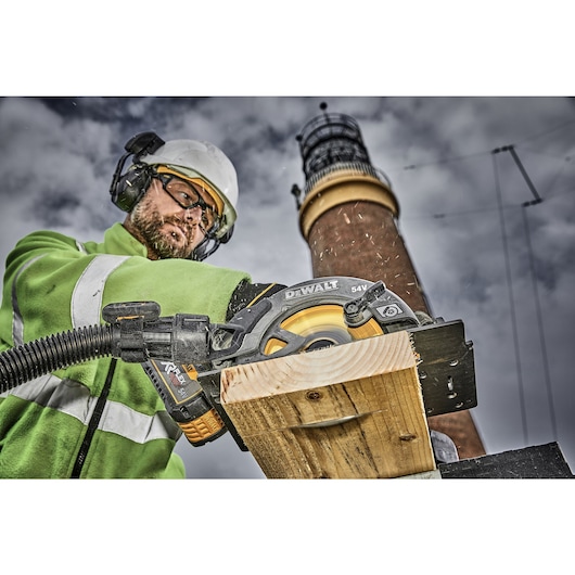 FLEXVOLT brushless cordless circular saw with brake kit being used by person on wooden plank.