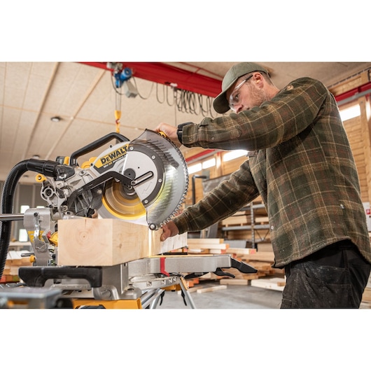The DEWALT 18V XR 305mm Slide Mitre Saw being used by carpenter in wood shop