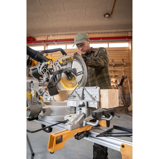 The DEWALT 18V XR 305mm Slide Mitre Saw being used by carpenter in wood shop