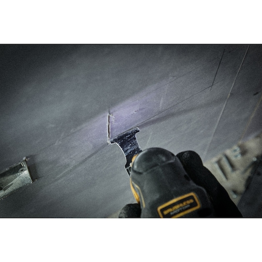 Close up shot of oscillating blade being used to cut into plasterboard