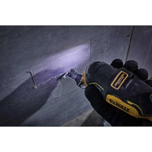 Close up shot of oscillating blade being used to cut into plasterboard