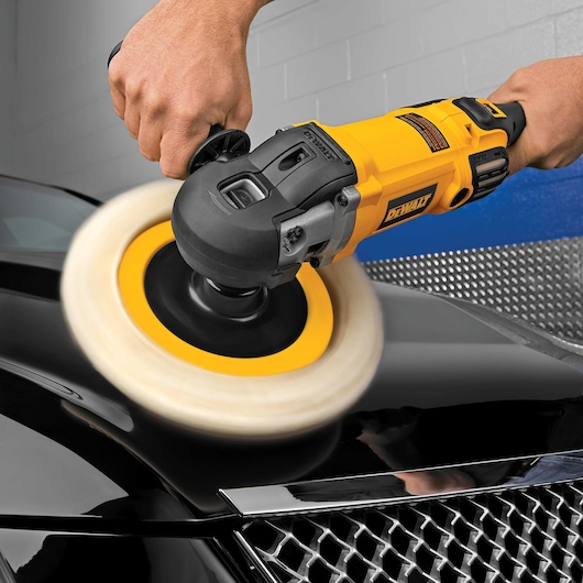 Variable speed polisher with soft start being used to polish car.