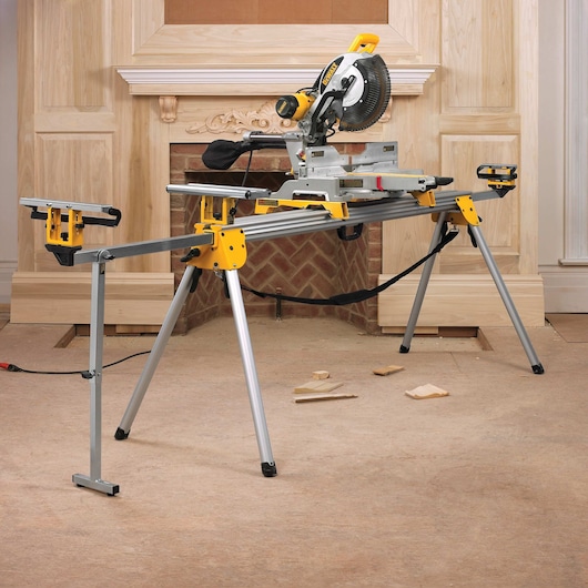 12 inch double bevel sliding compound miter saw with pieces of wooden on floor.